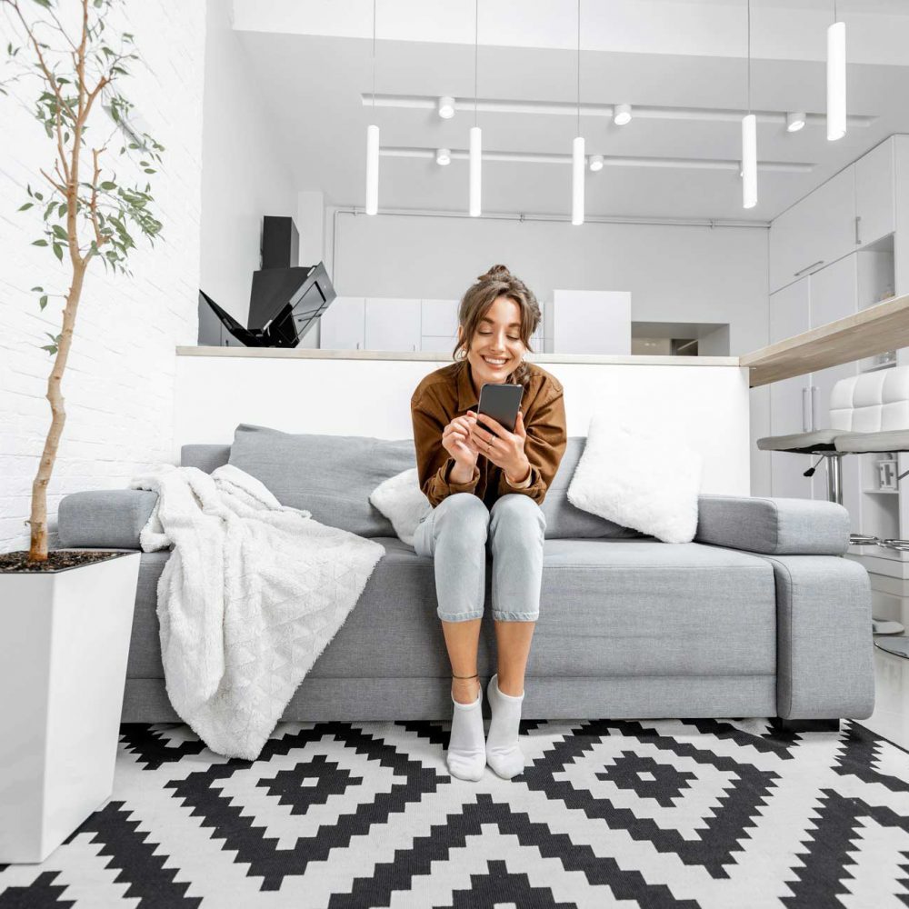 woman-with-phone-at-home-KWR9QTA-p4zb9f4k2tj4vop4uq68ecttkf5orspkaaguiu0xsg